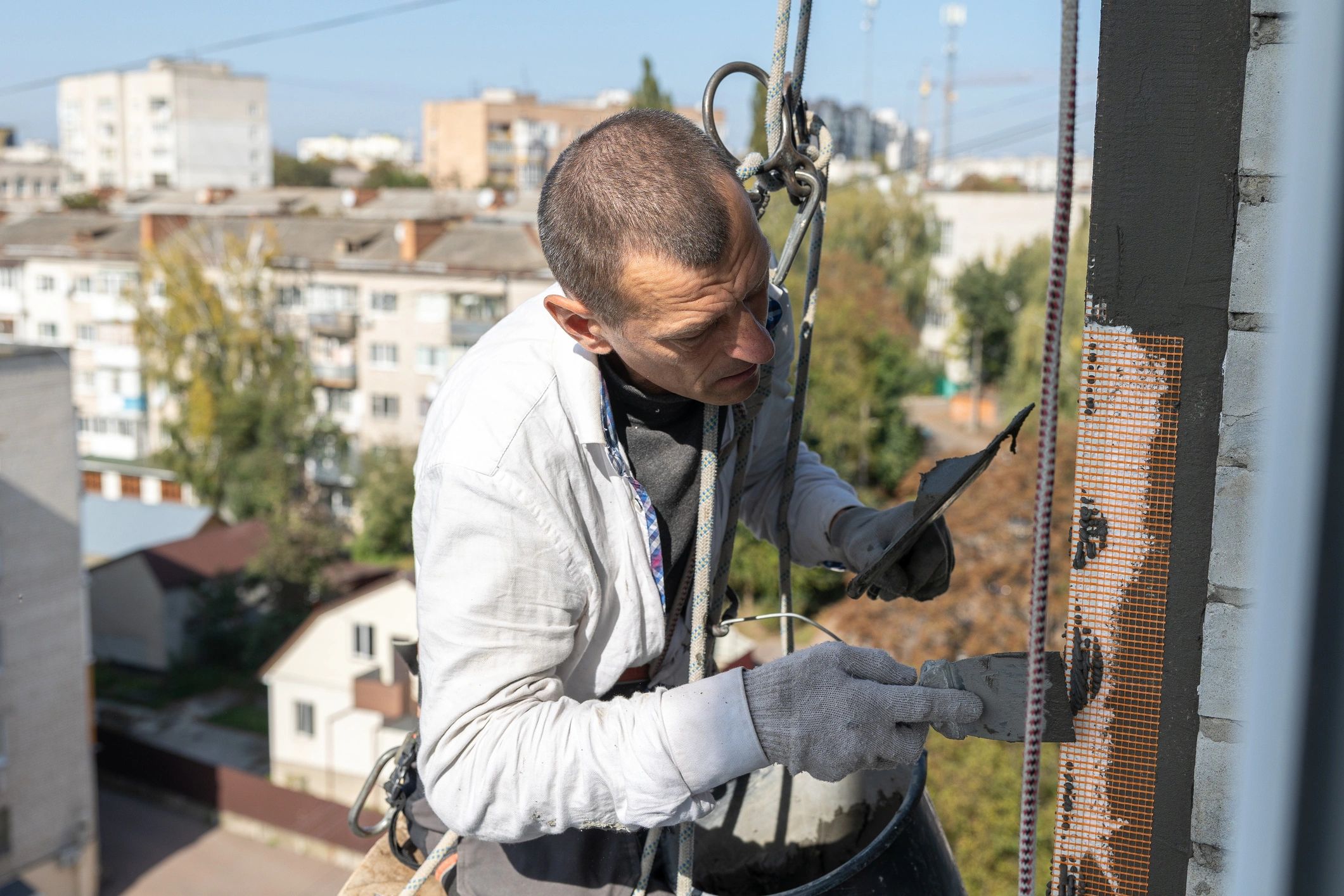 Worker applying exterior render to a building facade